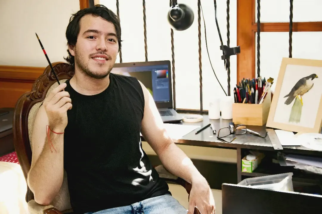 Miguel dibujando en su mesa de trabajo