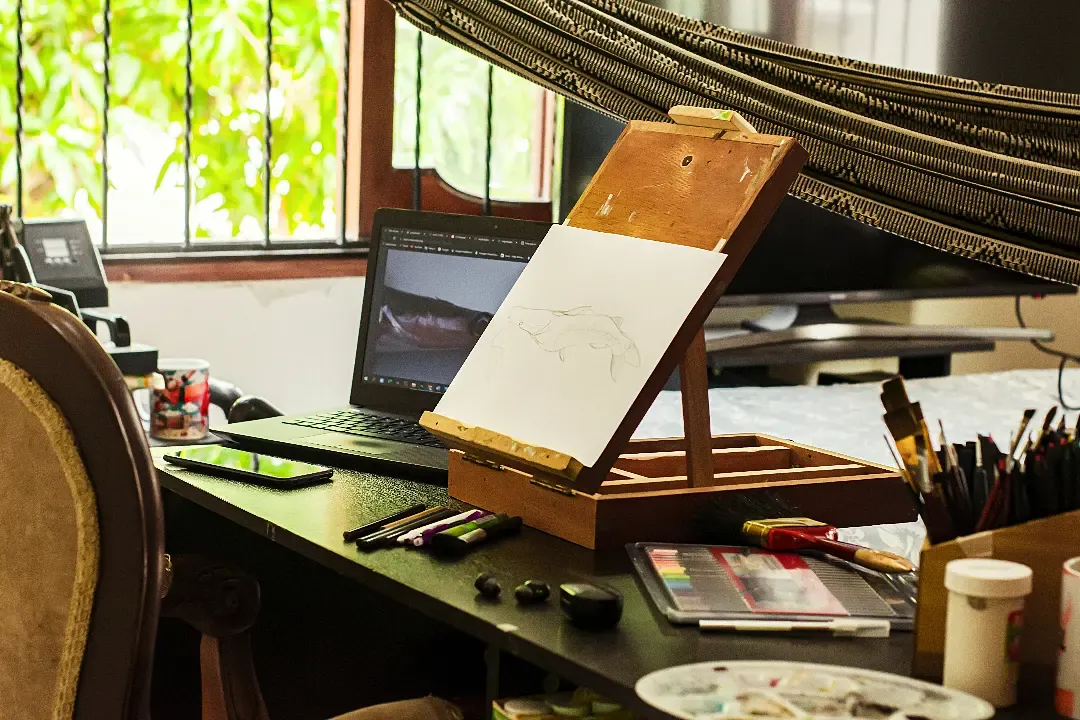 La mesa de dibujo con pinceles, tableta y la lámina en proceso